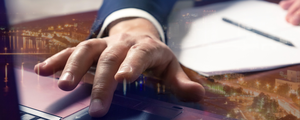 Close-up of a hand using a laptop touchpad with a cityscape overlay, representing strategies for engaging leads through email marketing in affiliate marketing