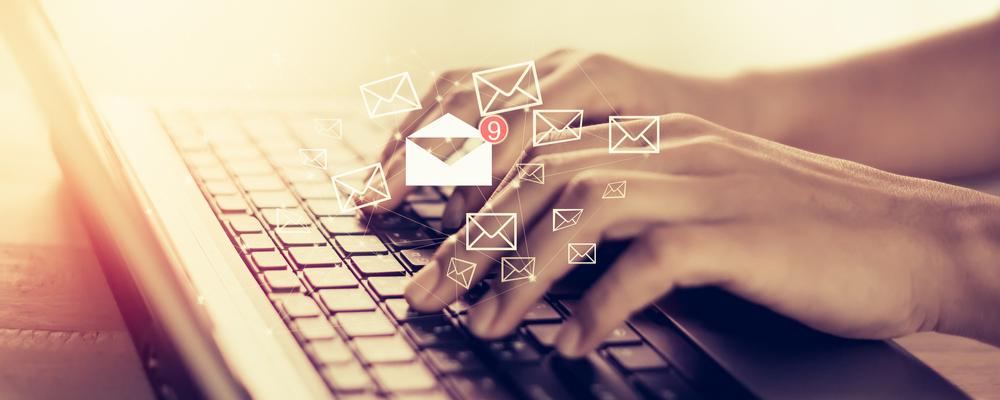 Hands typing on a laptop keyboard with email icons and notifications overlay, symbolizing strategies to enhance the effectiveness of email marketing efforts in affiliate marketing